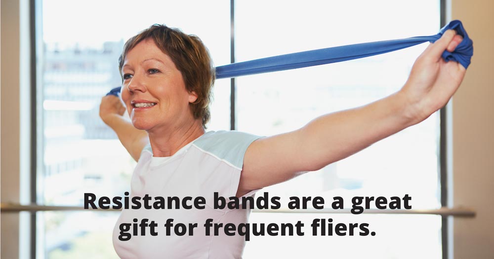 A woman uses a resistance band. Text says: Resistance bands are a great gift for frequent fliers.